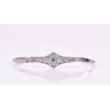 An Art Deco style diamond and emerald bracelet set with a single round-cut emerald in a diamond-