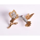 A diamond brooch in the form of a hummingbird feeding from a flower, the hummingbird with diamond