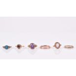 A group of six rings to include a 9ct rose gold wedding band, a 9ct yellow gold and garnet ring, a