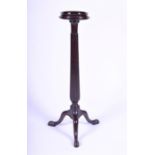A Victorian mahogany torchere raised on a reeded column above a tripod base with three cabriole legs