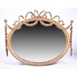 An 19th century gilt gesso oval wall mirror elaborately crested with ribbons, floral swags and