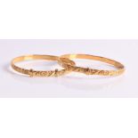 A pair of 14ct yellow gold baby bangles each with stylised floral decoration. (2) CONDITION REPORT