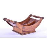 A George III mahogany cheese coaster of boat-shaped form, with turned carrying handles,  44 cm long.