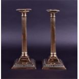 A pair of early 19th century brass candlesticks of Corinthian column form, with reeded columns on