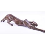 A large art deco style study of a prowling panther in marbled-effect brass, 108 cm long x 27 cm