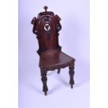 A late Victorian carved walnut hall chair designed with pierced back and scrolled work, above