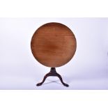 A Georgian mahogany tilt top supper table supported on a turned tapered column to three cabriole