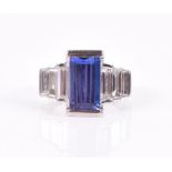 An impressive diamond and tanzanite ring set with an emerald cut tanzanite of approximately 3.12