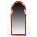 A decorative red lacquered wall mirror decorated in the Chinoiserie style of shaped arched form,