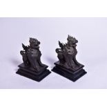A pair of bronze dogs of Fo mounted on ebonised wooden rectangular plinths, 25 cm high.