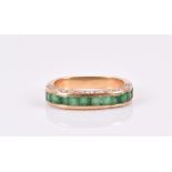 An 18ct yellow gold, diamond, and emerald half eternity-style ring calibre-set with a line of