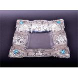 A contemporary silver embossed tray with shell, flower and leaf decoration, set with blue paste