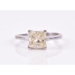 A 14ct white gold and pale yellow diamond ring set with a princess-cut stone of approximately 1.35