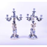 A pair of Continental Sitzendorf porcelain four branch candelabra each decorated with a seated