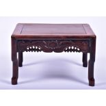 A Chinese hardwood small low table with carved and pierced frieze on four shaped legs, with a mid