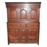 An 18th century oak court cupboard the top with three panelled doors on a base of three frieze