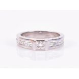 A platinum and diamond ring set with a princess-cut diamond of approximately 0.25 carats, the