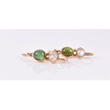 A pair of yellow metal, moonstone, and green tourmaline earrings each set with a cabochon cut