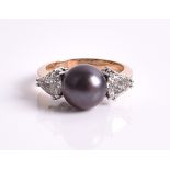 A black Tahitian pearl and diamond ring centred with a black Tahitian pearl measuring