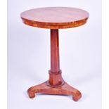 A late Regency walnut circular occasional table raised on an octagonal tapering column above a