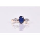 An 18ct yellow gold, diamond, and sapphire ring the oval-cut sapphire flanked with two marquise-