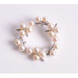 A pearl and diamond scarf ring of circular open-worked form, with floral diamond-set details, in