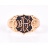 A yellow metal and black enamel signet ring with shield-shaped mount inlaid with initials, shank