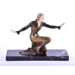 An Art Deco painted spelter figure of a dancing girl in a kneeling position with arms