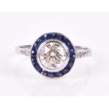 A white gold, diamond, and sapphire target ring set with a round brilliant-cut diamond of