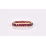 An 18ct yellow gold and ruby eternity ring calibre-set with square-cut rubies, size N, 2.6 grams.