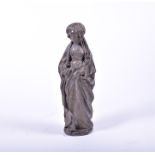 A tall plaster figure of a woman in medieval dress with carved long flowing robes and plaited