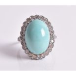 A turquoise and diamond ring the central oval cabochon turquoise within a border of twenty-four