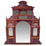 A large late Victorian carved mahogany overmantel mirror architecturally designed with turned