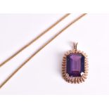 A synthetic pendant the emerald-cut purplish blue stone mounted in a rose gold coloured gilt