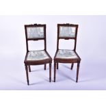 A pair of late Victorian carved oak chairs with printed upholstered seat and back, carved with