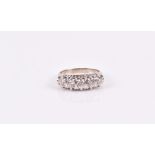 A white metal and diamond ring set with five round-cut stones of approximately 0.65 carats, size L