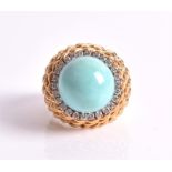A turquoise and diamond dome dress ring centred with a circular cabochon turquoise within a border