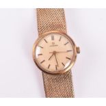A 9ct gold Omega ladies wristwatch with gilt baton dial, on textured strap, stamped 375, 32 grams.
