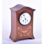 An Edwardian mahogany mantel clock the white enamel dial with black Arabic numerals, set within a