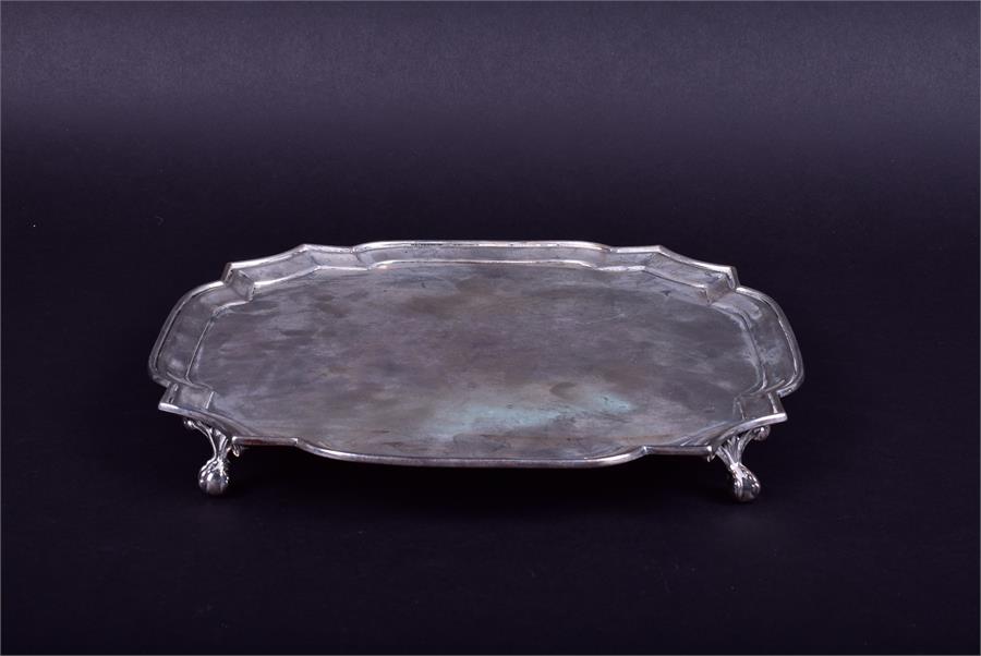 A George V silver salver of shaped square form by Edward Barnard & Sons Ltd, London 1926, on four