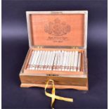 A walnut and parquetry inlaid cigar box and approximately 60 'custom rolled' cigars the hinged lid