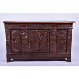 A 17th century Dutch carved oak coffer extensively carved with religious scenes sectioned in panels,