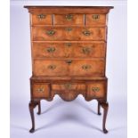 An early 18th century walnut chest on stand with inverted moulded cornice over three narrow