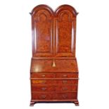 A Queen Anne style burr walnut bureau bookcase with double dome top and arched doors enclosing three