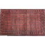 A large Eastern part-silk room carpet with repeating geometric motifs throughout, on a red ground,