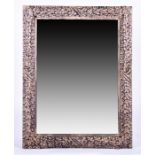 A contemporary metal-framed mirror the frame formed of stylised overlapping leaves, 120 cm x 90