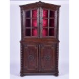 An 18th century Continental carved walnut vitrine cabinet the top framed with a leaf garland