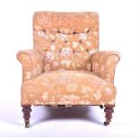 A late Victorian upholstered armchair with button upholstered back, supported on tapering turned