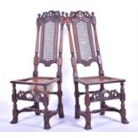 A pair of 17th century style oak dining chairs each with upright narrow caned backs flanked with