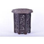 A small 19th century Indian carved octagonal table designed throughout with carved floral motifs,